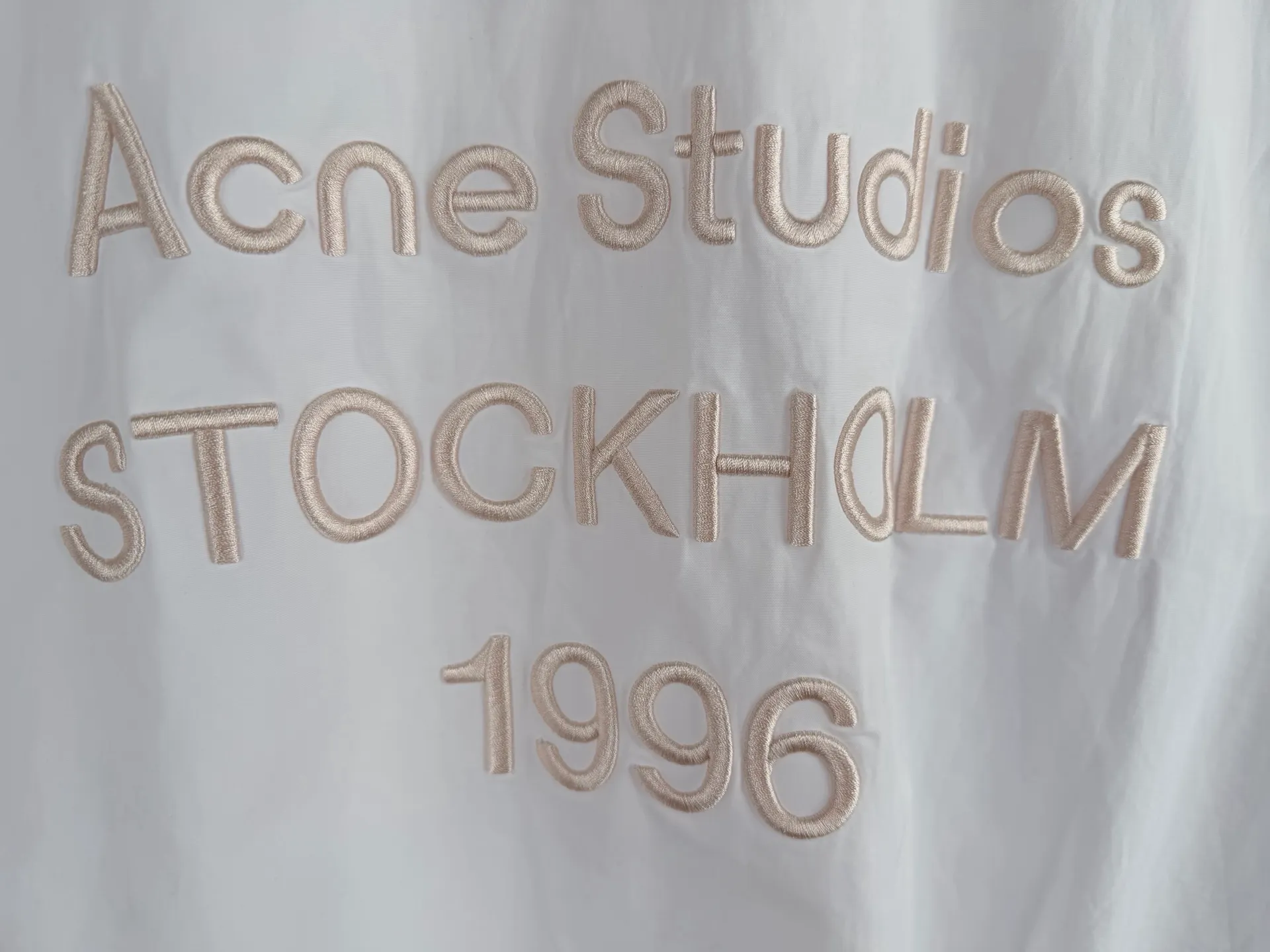 Acne Studios embroidered logo windbreaker jacket. Custom-made Ninglan light woven machine blend. Lightweight and windproof. Stiff and tough. Smoky pink and white calming. It embodies the cool and minimalist Scandinavian aesthetics. Stand-up collar with full zipper for neat opening and closing. Full lining on the inside to improve the smoothness of putting on and taking off. Elastic elasticated precision cuffs at the hem create a relaxed and loose cropped silhouette. Three-dimensional logo embroidery in the same color on the back. Engraved with STOCKHOLM. Chronicle The embroidery is integrated with the body of the garment, hiding the brand's traceability context. The minimalist shape integrates the functional core to interpret the relaxed and relaxed style of high-end ready-to-wear. Process 1: Using imported machine embroidery technology. Using advanced computer control systems and precision mechanical components to realize the Acne Studios logo embroidery operation. High precision. The lines are smooth and delicate. Process 2: The fabrics have been fermented and washed. They have a better hand feel and texture. They are not easy to deform, shrink or fade. Maintain long-term beauty Accessories: Customized 1:1 Acne webbing Customized 1:1 Acne zipper Customized 1:1 Acne trademark Version: Loose version Size: 44 46 48 50